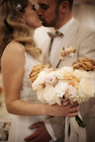Brautpaar küsst sich nach der Trauung mit Blumenstrauß bei einer Hochzeit in Darmstadt
